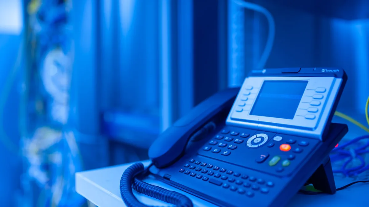 Close up of a modern office phone in blue lighting ideal