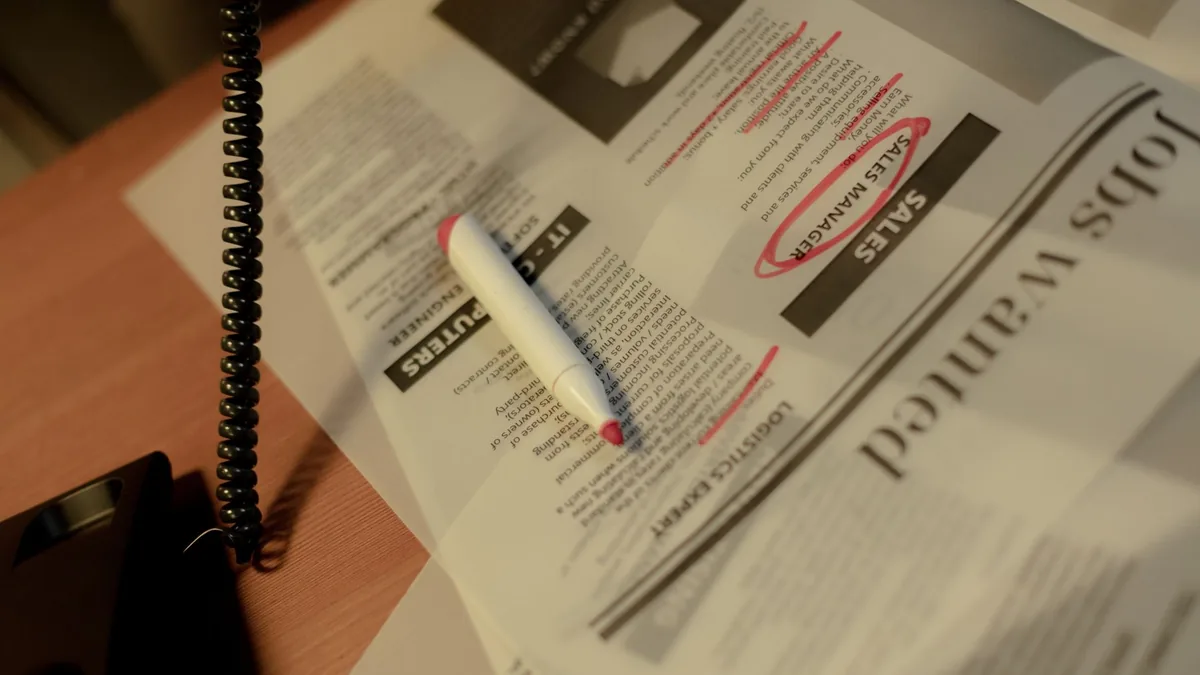 Close up of a newspaper job section with a red marker an