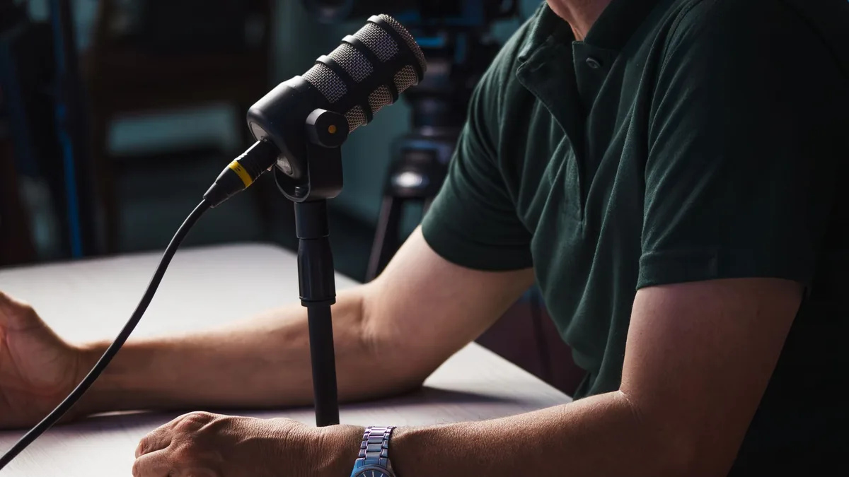 Close up of a person recording a podcast in a studio fea