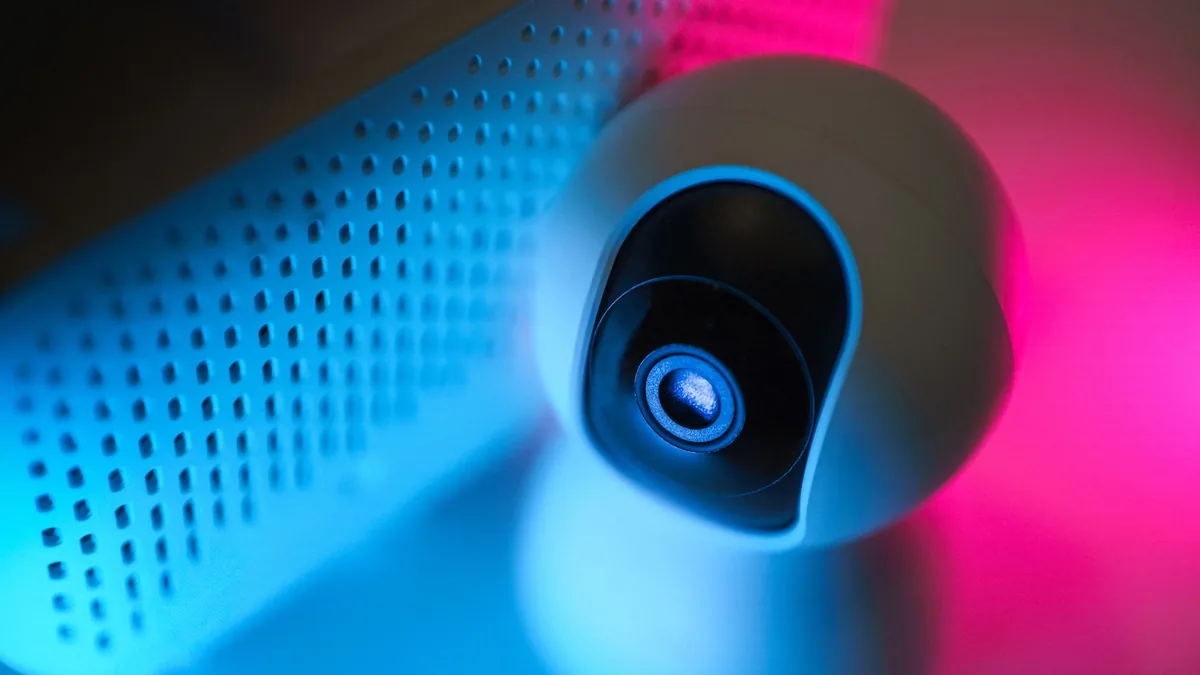 Close up of a surveillance camera with neon lighting sym
