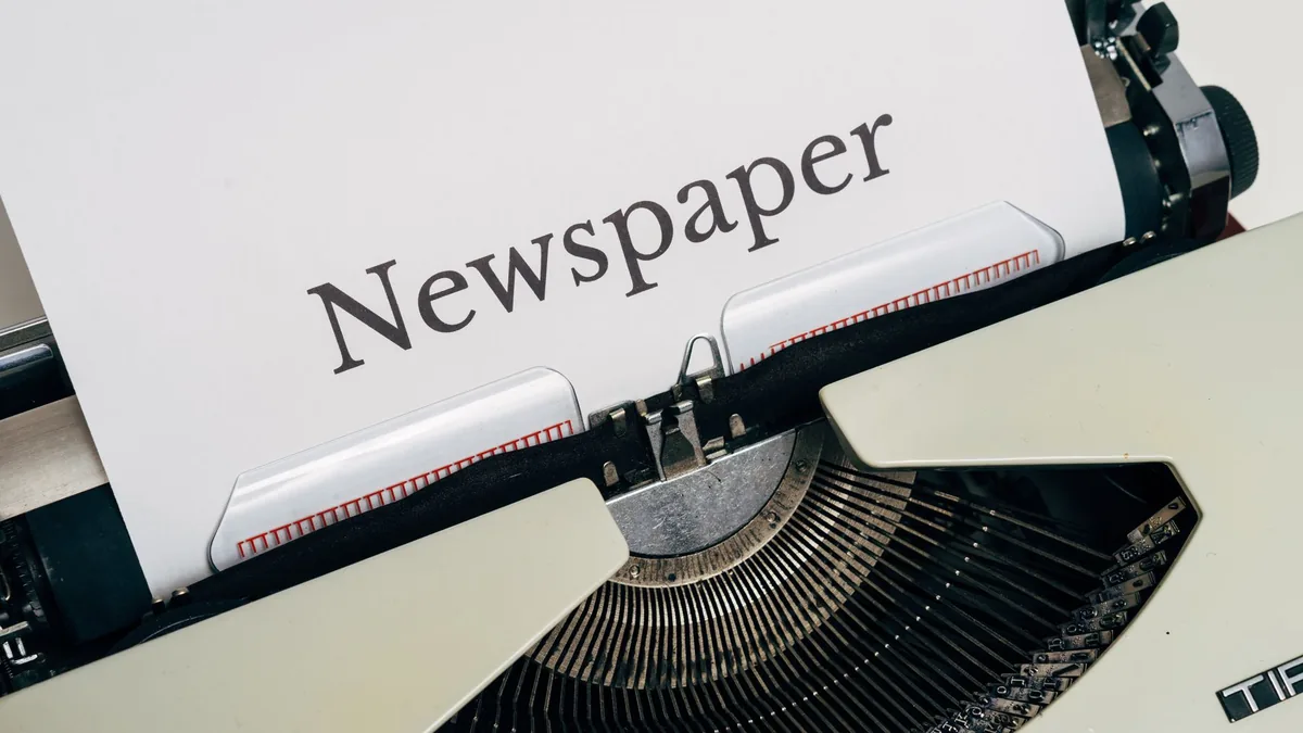 Close up of a vintage typewriter printing the word newsp