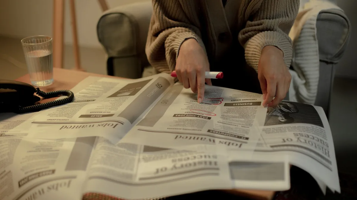 Close up of a woman reading job listings in a newspaper