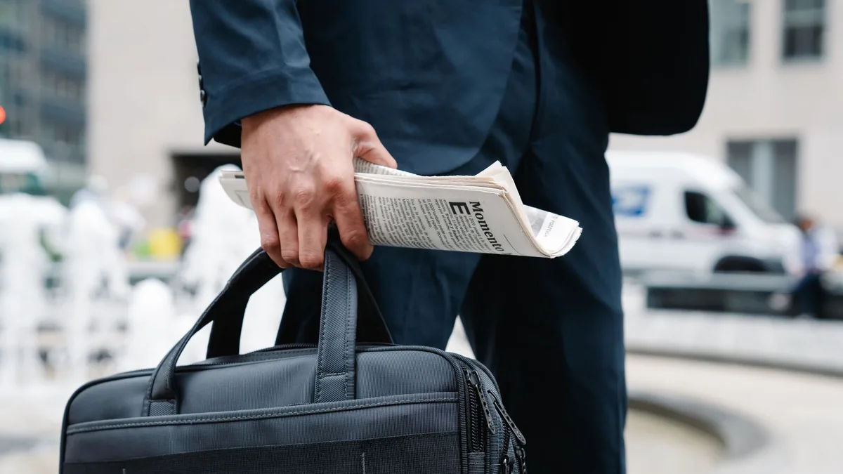 Close up of businessman in suit holding a briefcase and