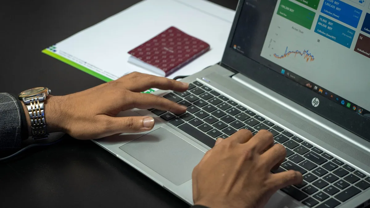 Close up of hands on a laptop keyboard with a business d