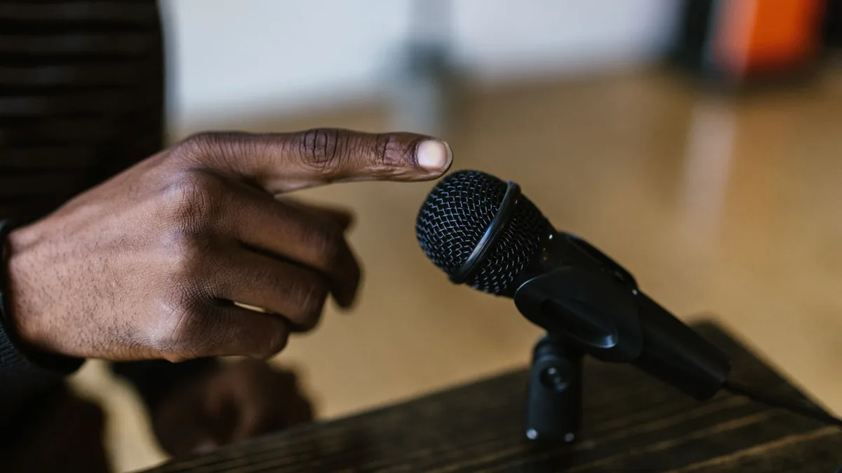 Close up shot of a hand touching a microphone ideal for