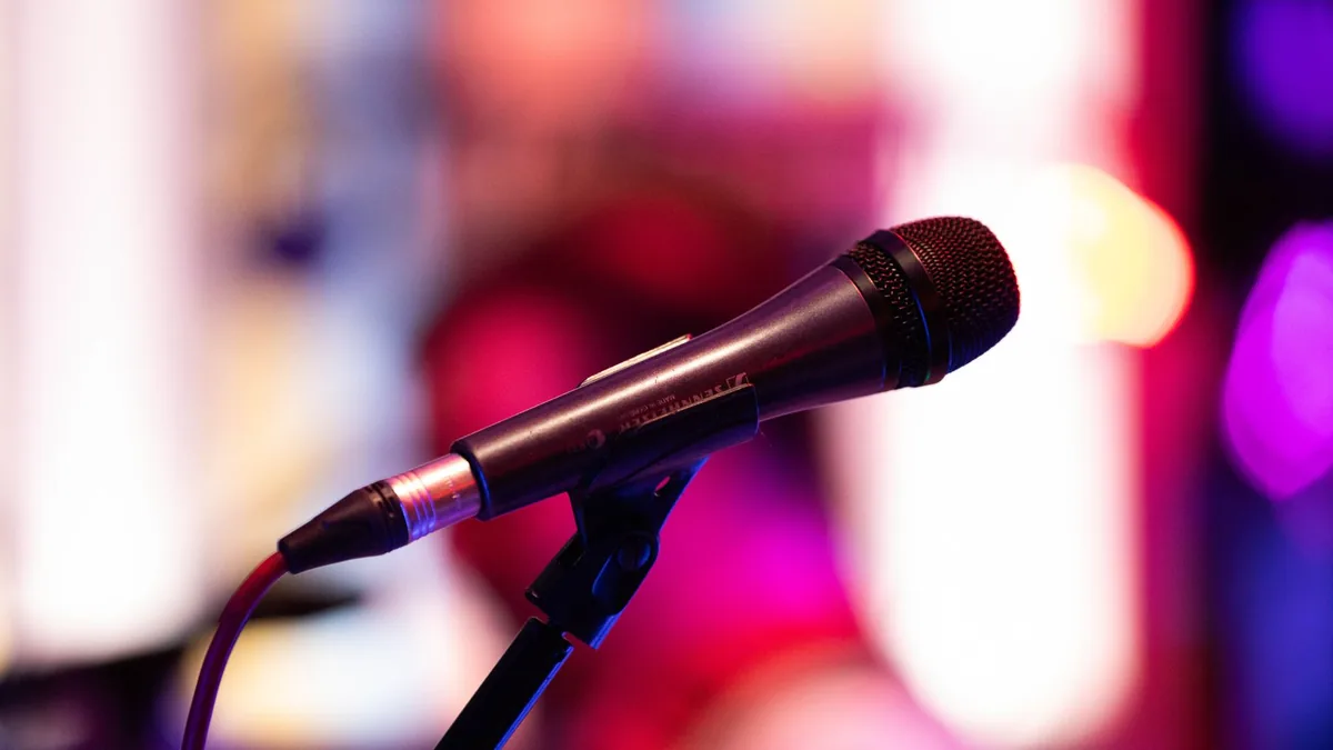 Close up shot of a microphone on stage with colorful bac