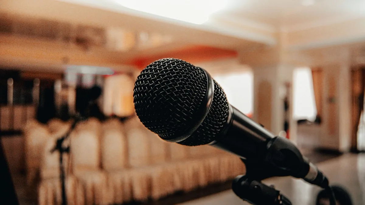 Closeup of black modern microphone on stand placed in sp