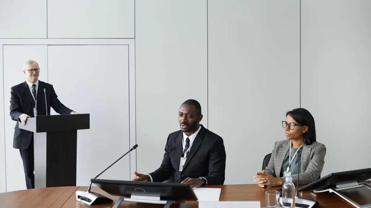 Colleagues in corporate attire discussing at a business