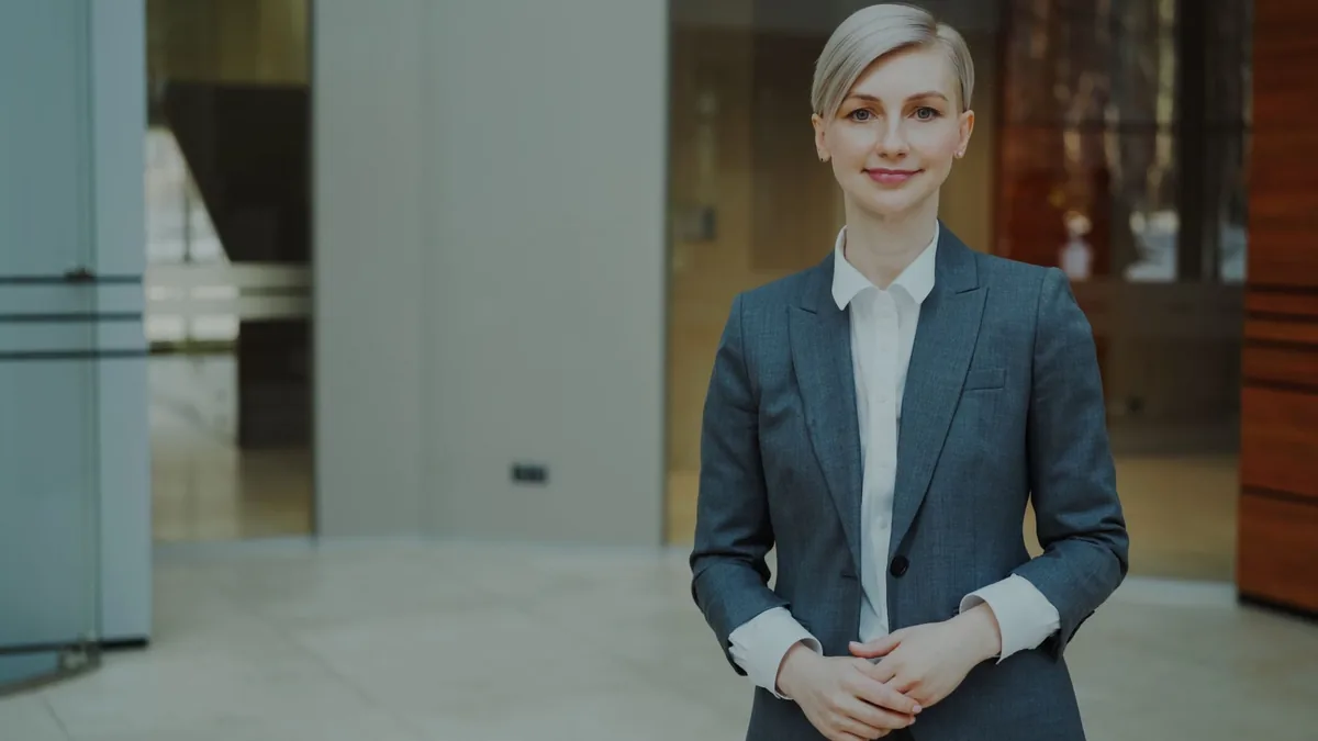 Confident businesswoman in a suit standing indoors in an