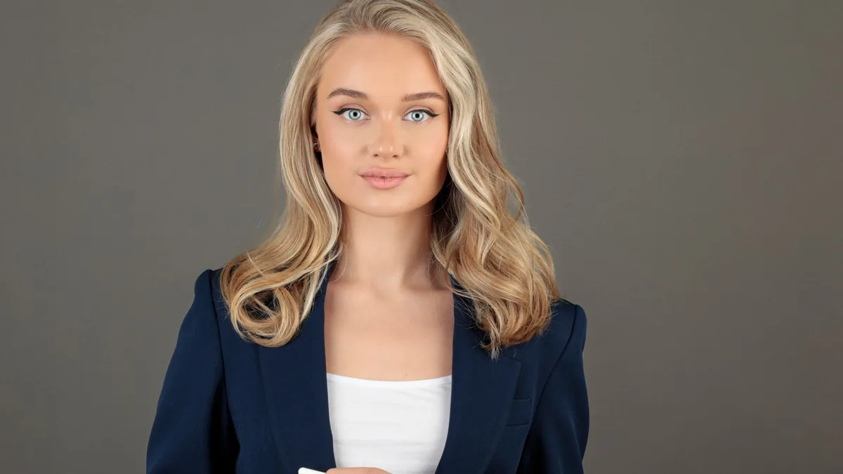Confident businesswoman in blue suit holding tablet depi