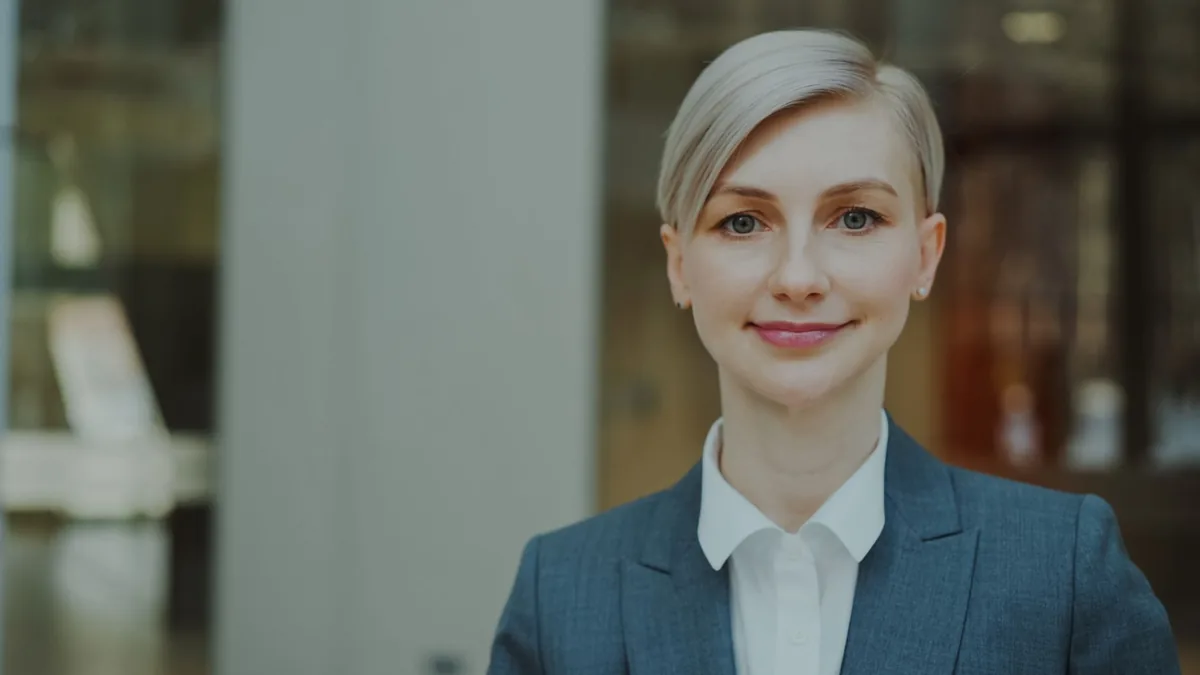 Confident businesswoman in formal attire smiling indoors