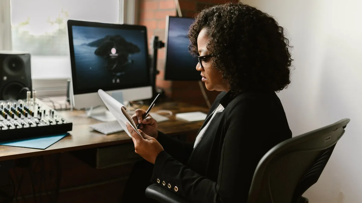 Confident businesswoman writing notes while working in a