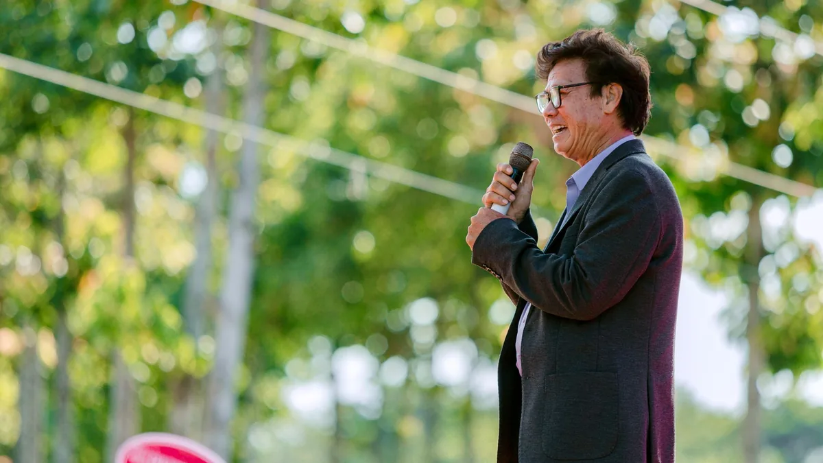 Confident man giving an outdoor speech with lively trees