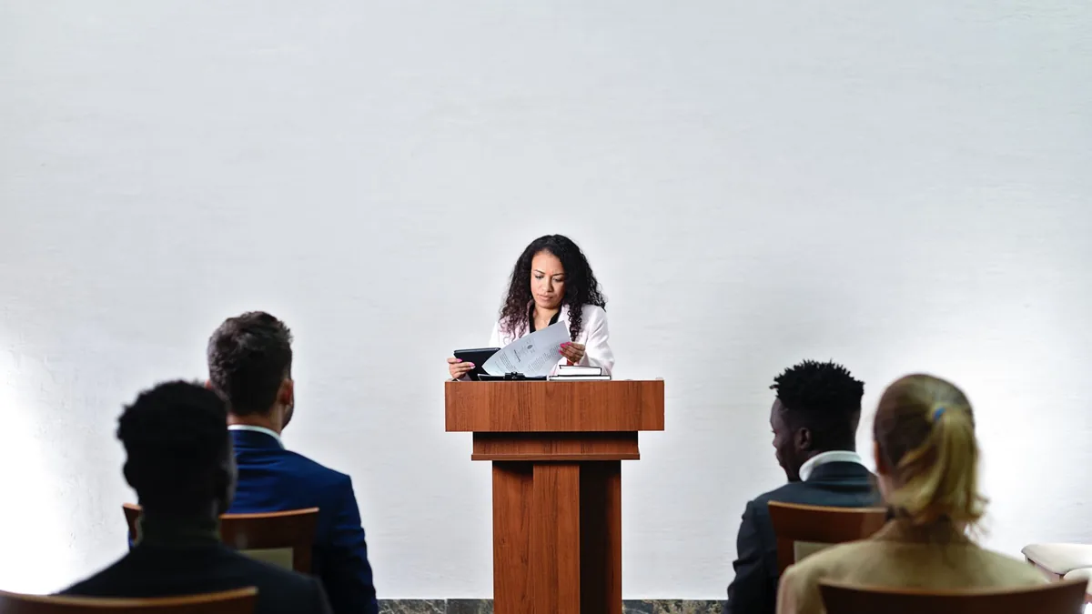 Confident woman delivering a speech to a diverse audienc