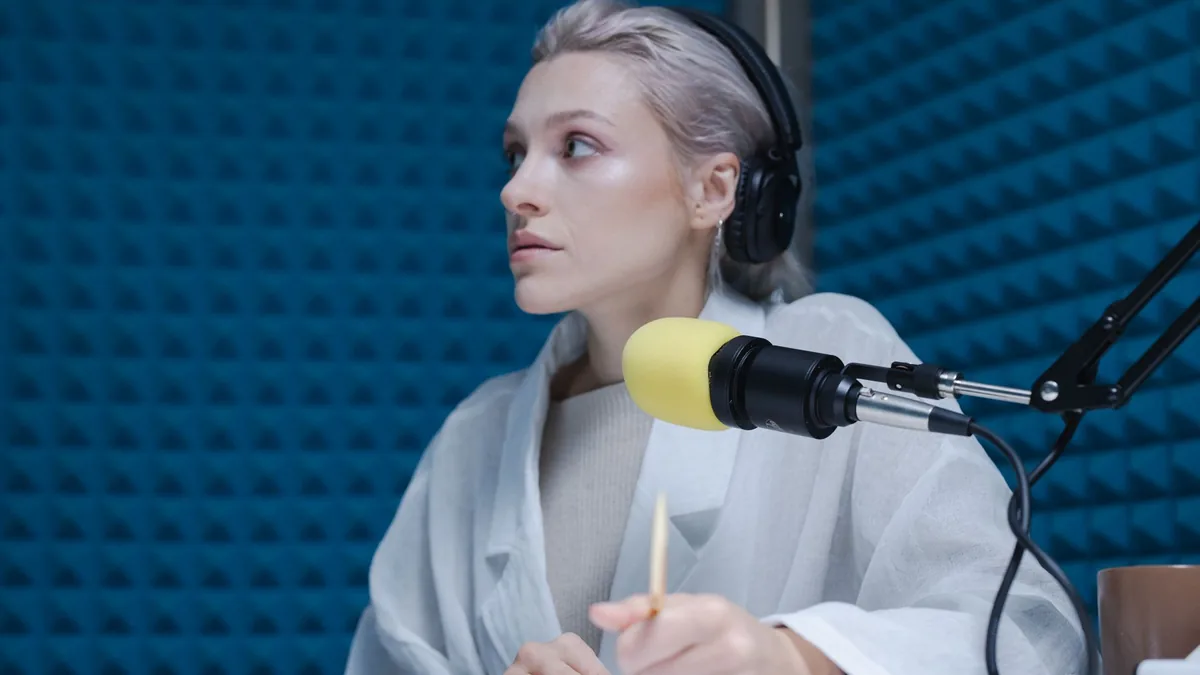Confident woman wearing headphones hosting a podcast in