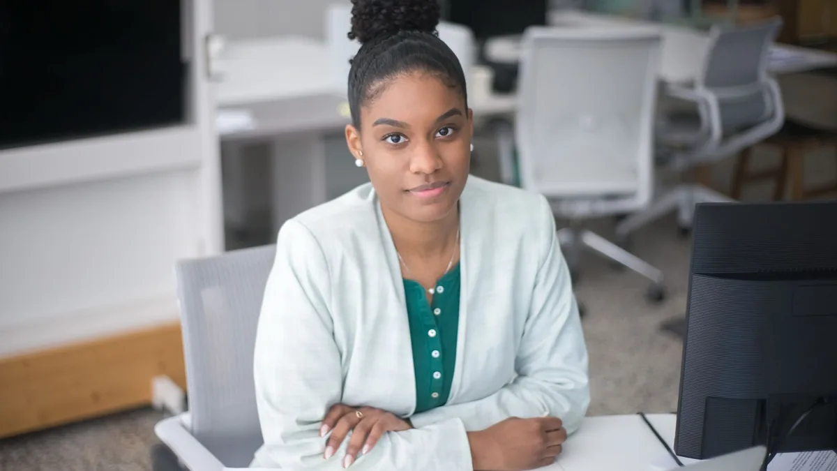 Confident young woman working at her desk in a bright mo