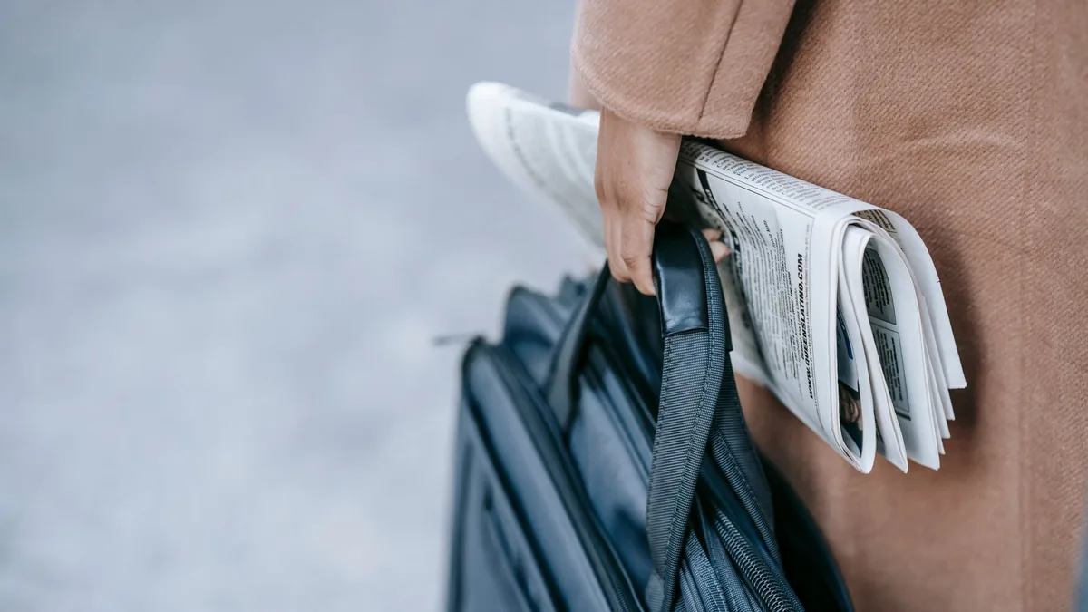 Crop anonymous female entrepreneur in elegant brown coat