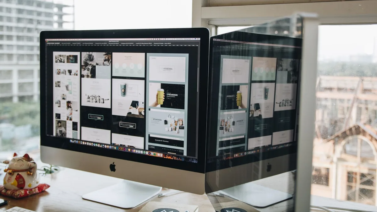 Dual monitors on a desk showcasing web design in a moder