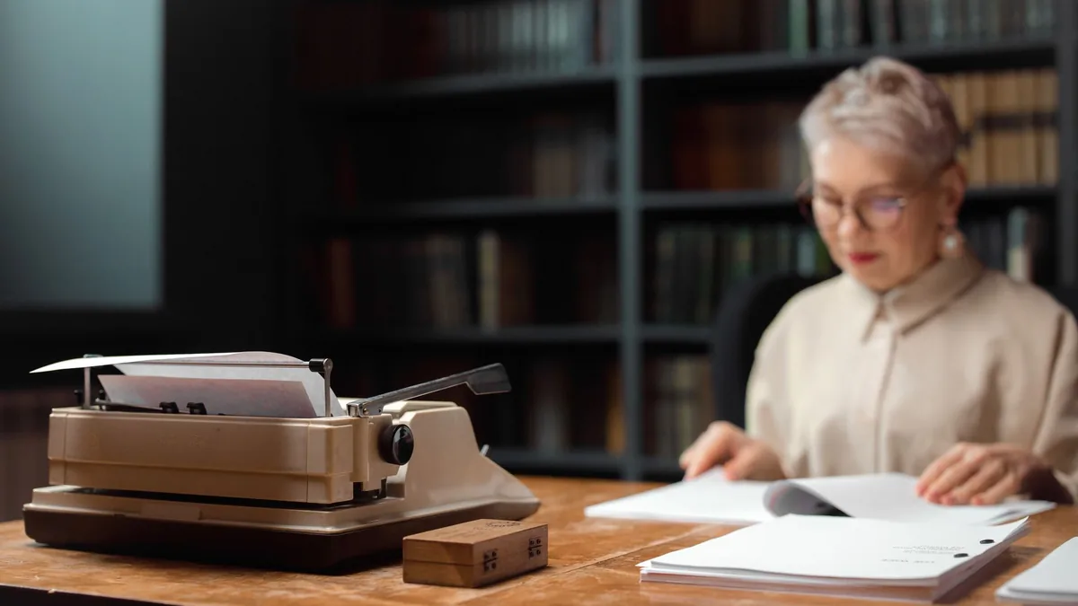 Elderly woman reviewing documents at a desk with a vinta