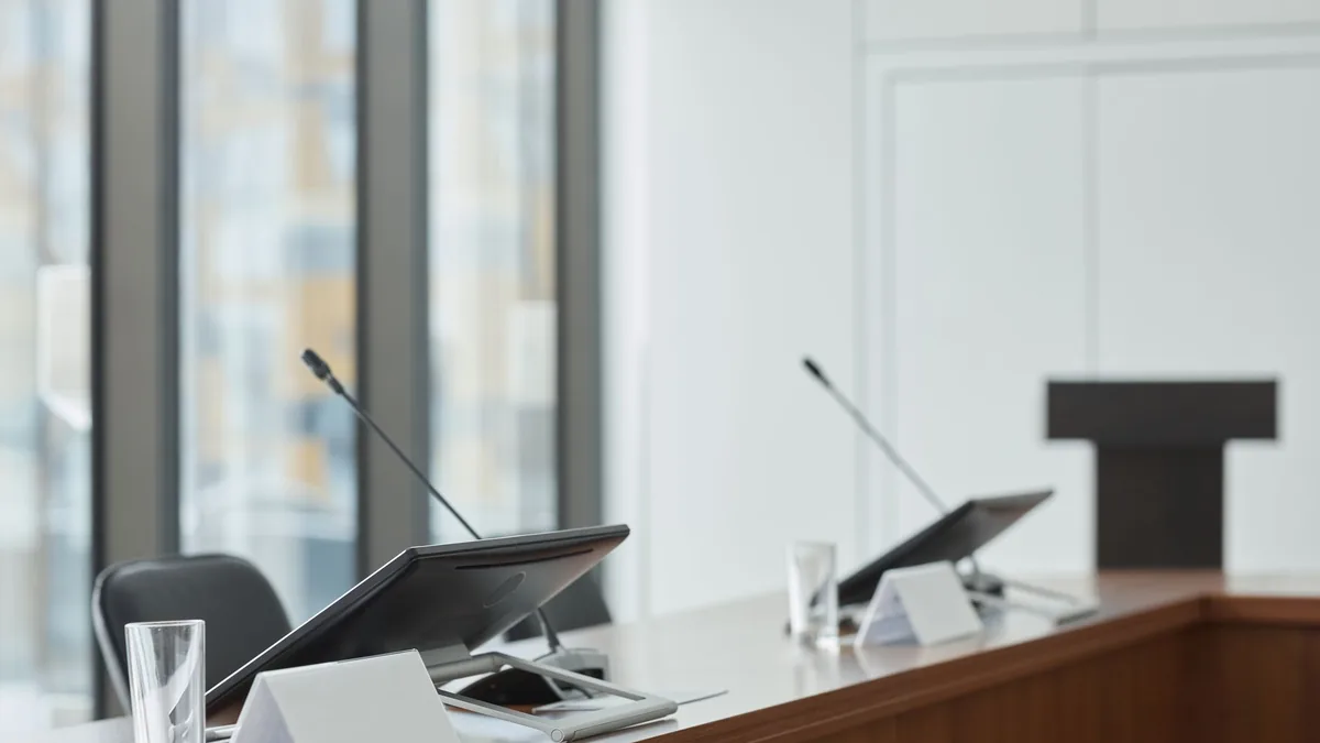 Empty boardroom with microphones monitors and clear wind