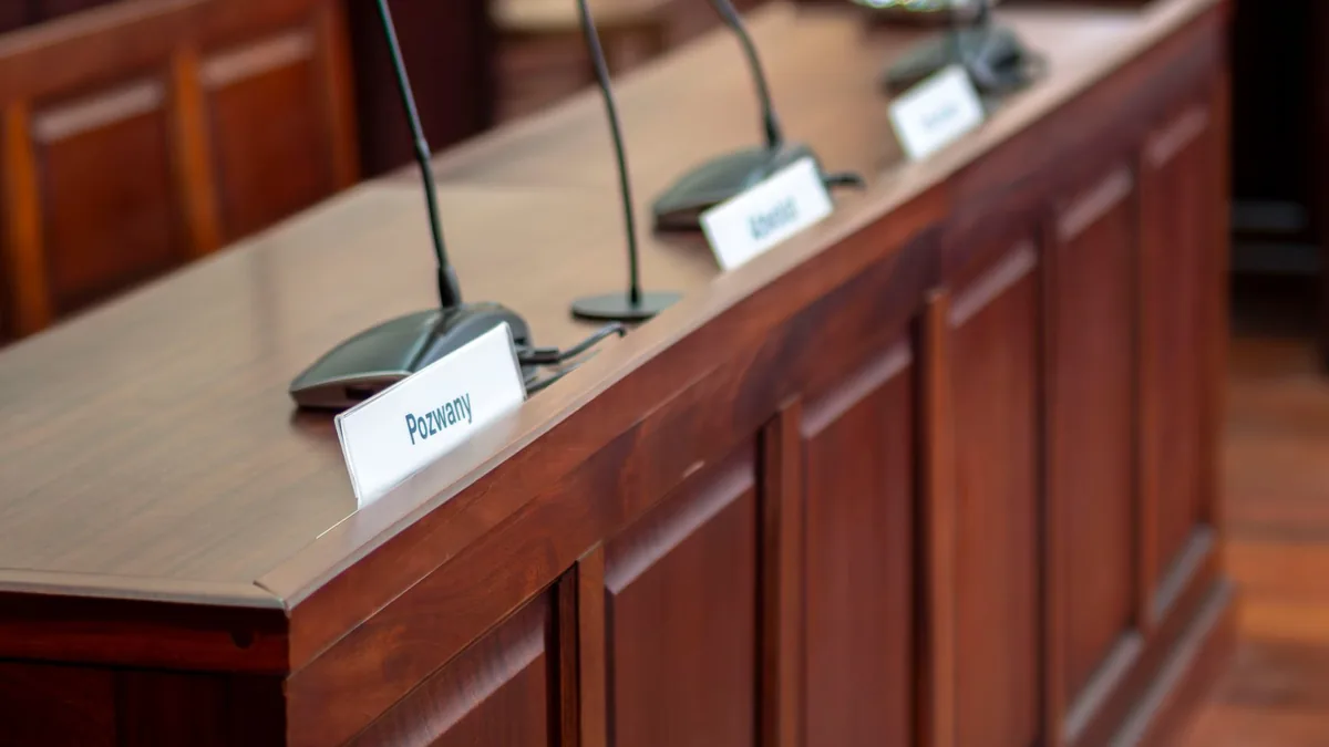 Empty courtroom desk with microphones and nameplates in