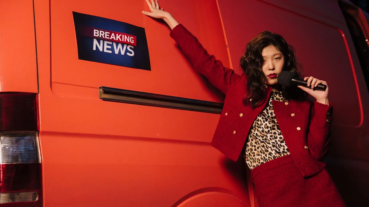 Fashionable reporter with microphone posing dramatically