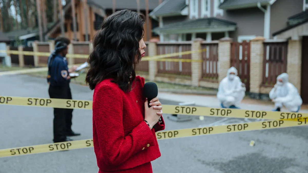 Female journalist reporting live on a crime scene invest