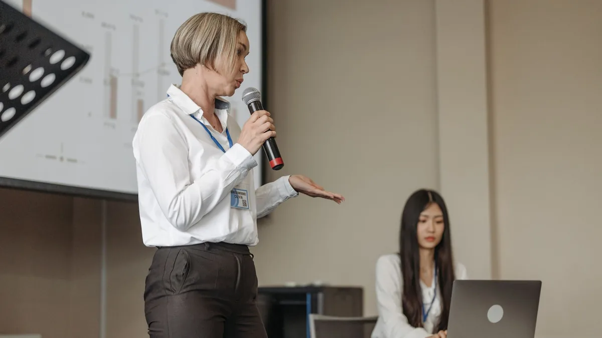 Female speaker presenting at a business conference with