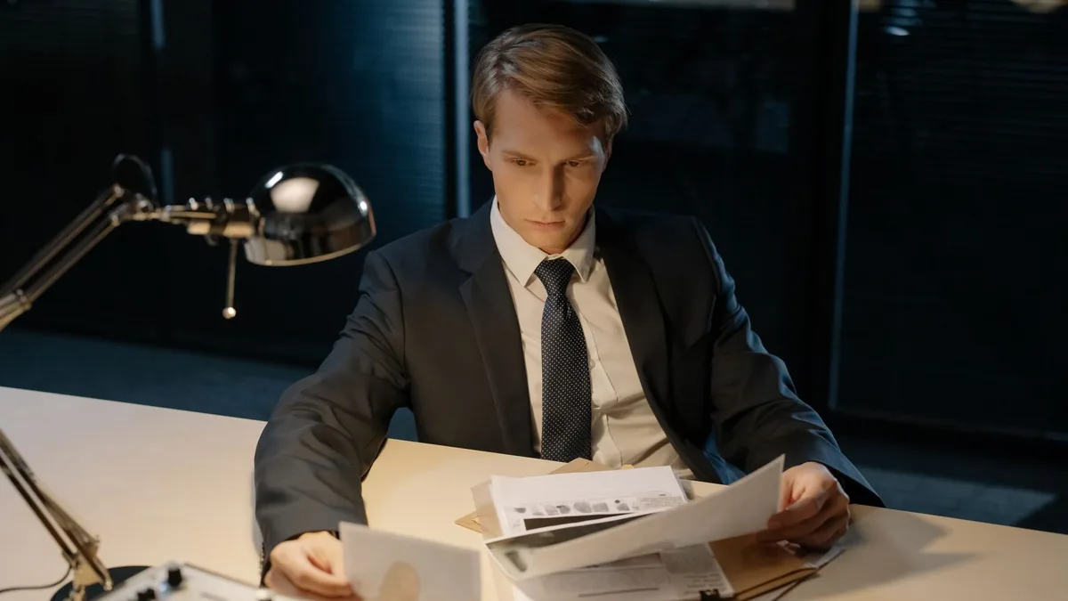 Focused investigator reviewing evidence in a dimly lit o