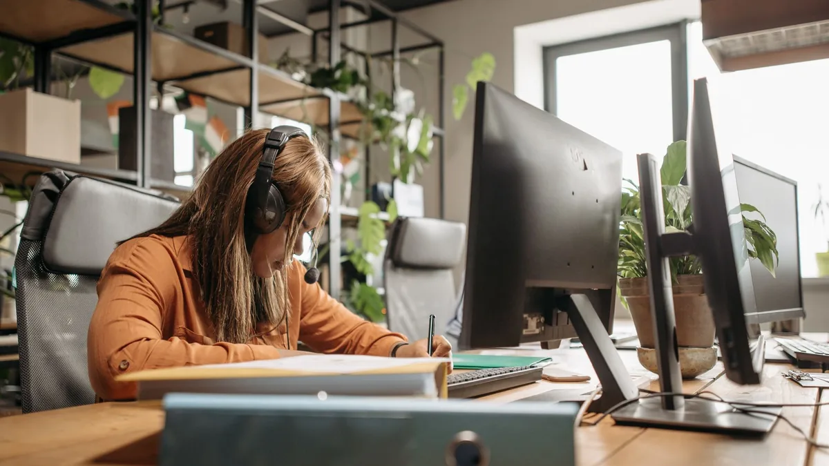 Focused woman with headset working in a modern office en