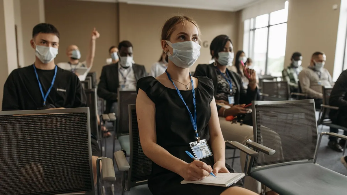 Group of professionals wearing masks during an indoor bu