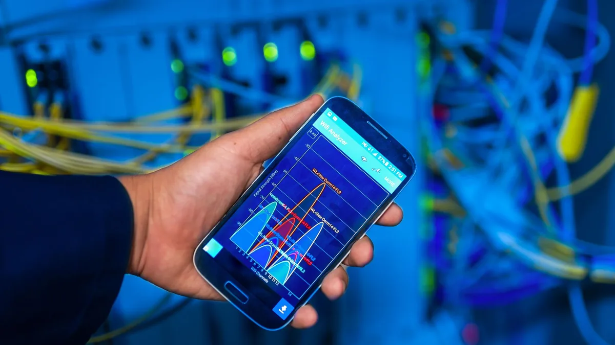 Hand holding smartphone displaying network analysis in h