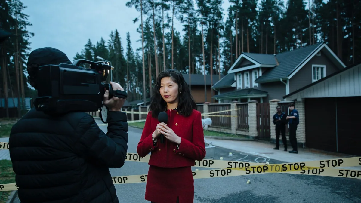 Journalist reporting live from a taped crime scene with