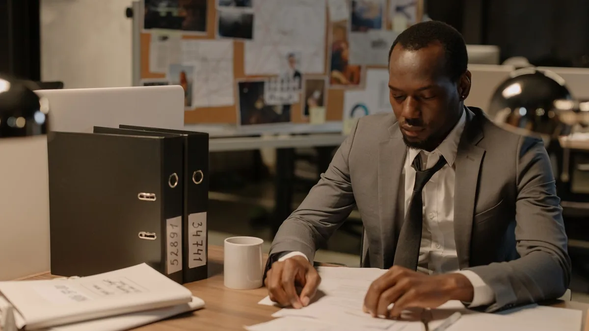 Man in business suit working late at office desk with do