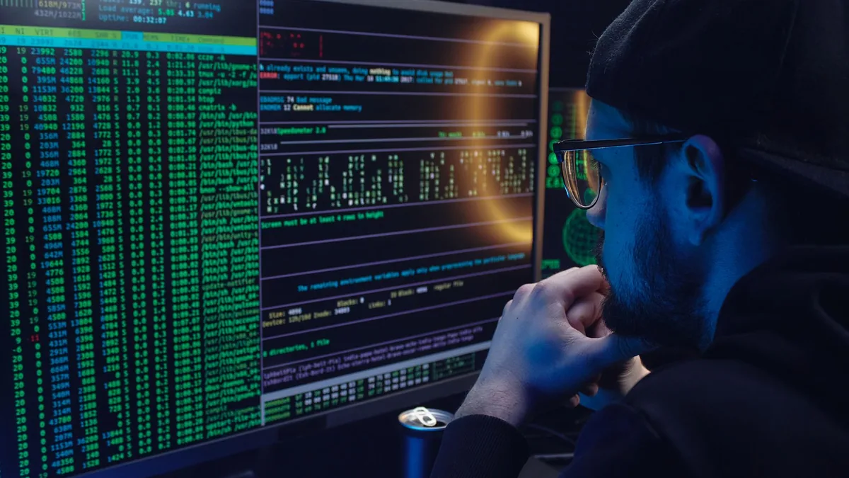 Man intently working on computer programming with code d