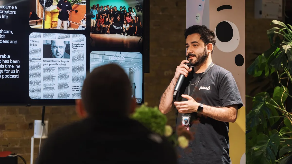 Man presenting with microphone at indoor conference enga