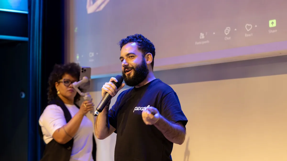 Man presenting with microphone while woman records with