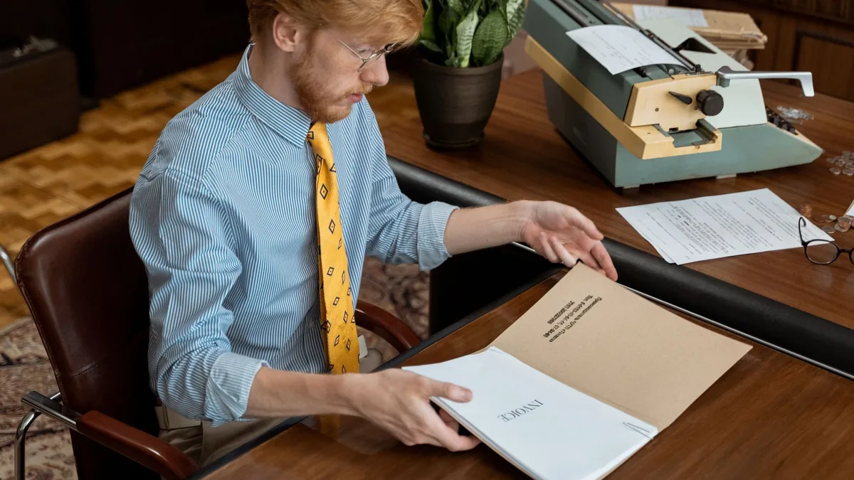 Man reviewing documents at vintage office desk with type