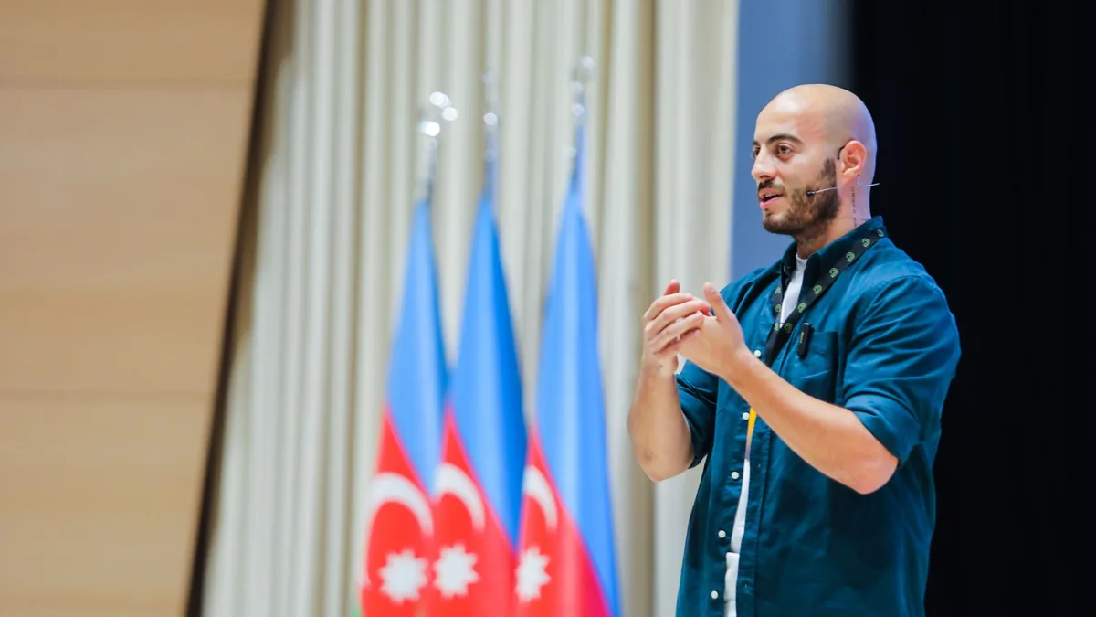 Man speaking at an event in baku azerbaijan with azerbai