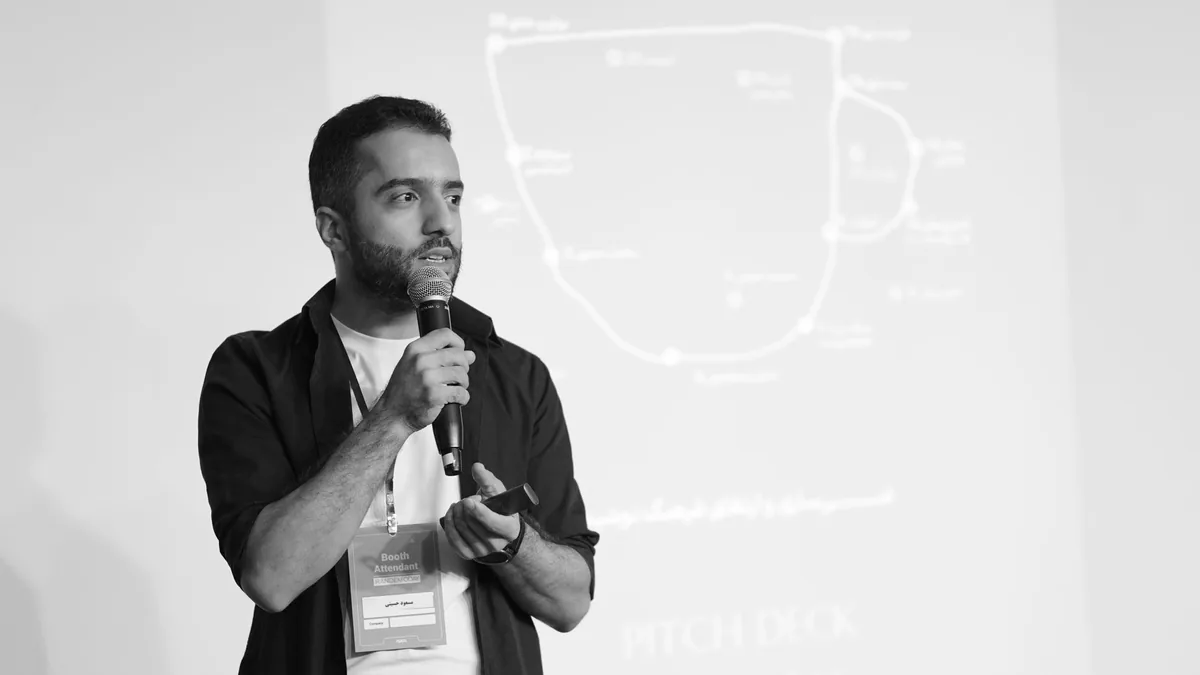 Man speaking into a microphone during a business seminar