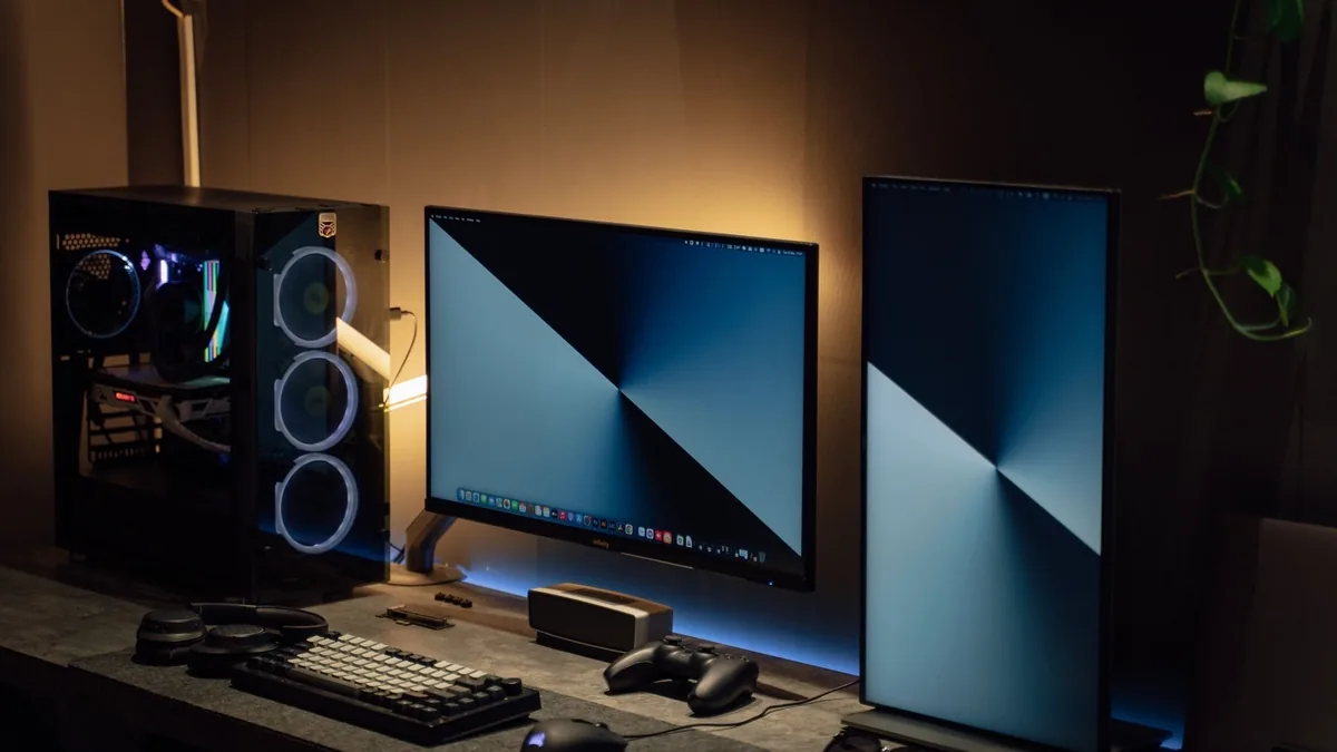 Modern dual monitor pc setup with tech gadgets on a slee