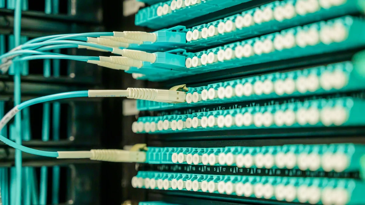 Networking cables plugged into a patch panel showcasing