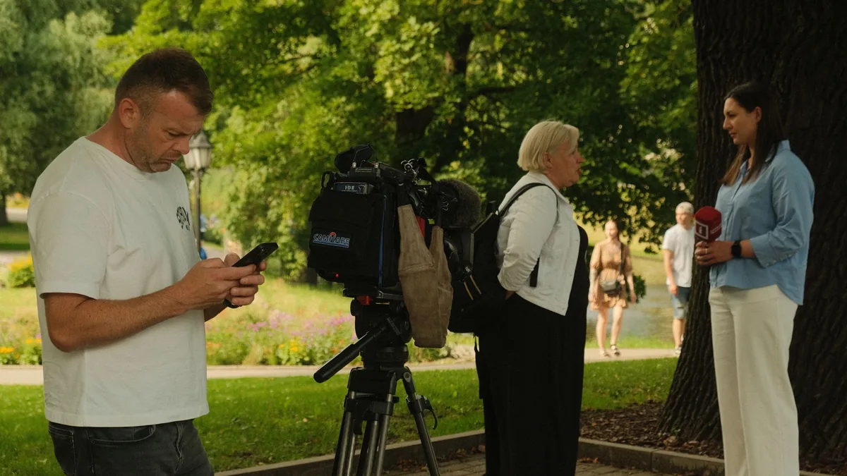 News crew conducting outdoor interview with professional