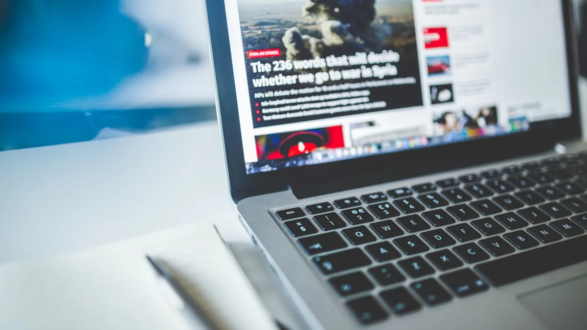 Open laptop displaying an online news article on a desk