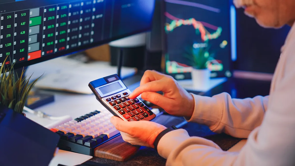 Person using a calculator in a digital office for stock