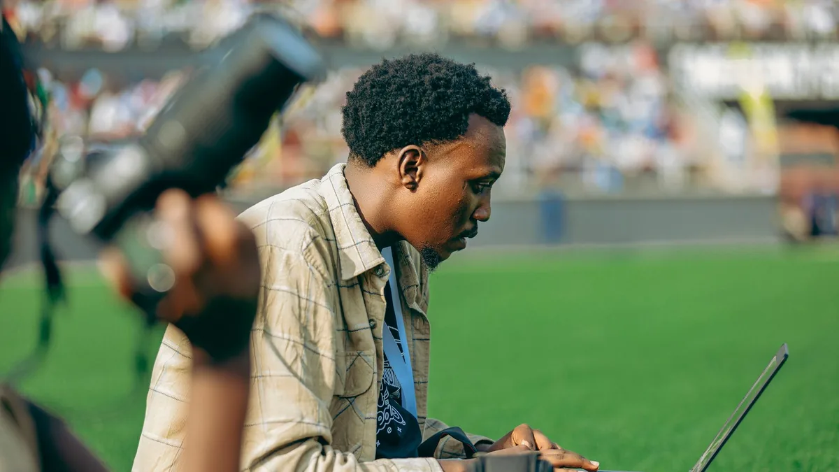 Photographer using a laptop at an outdoor event on a sun