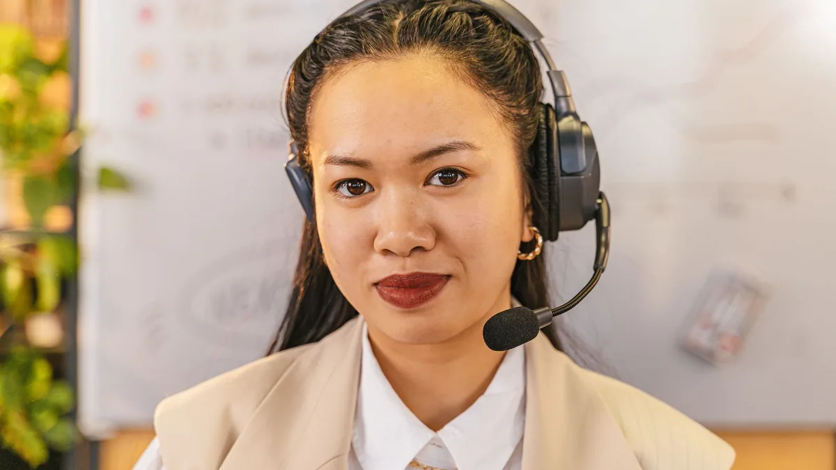 Professional asian woman in headset smiling confidently