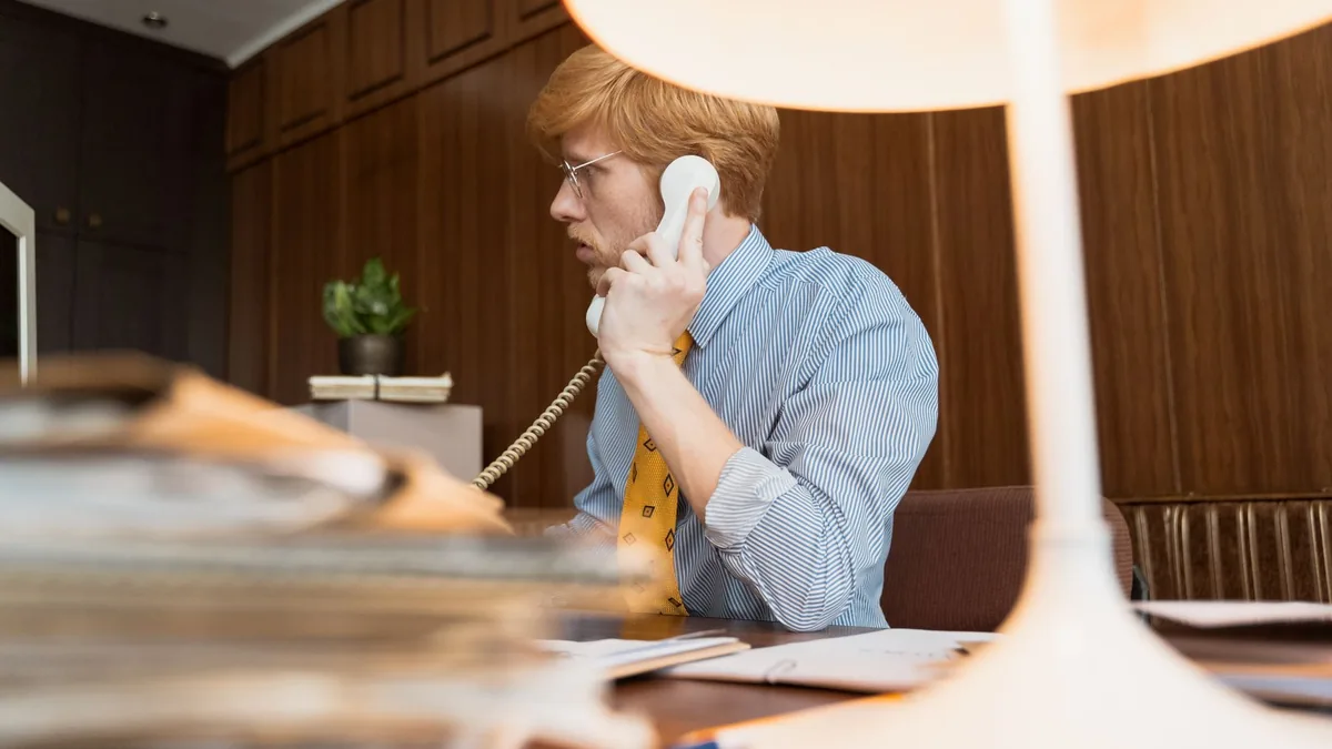 Professional man with eyeglasses talking on a vintage te