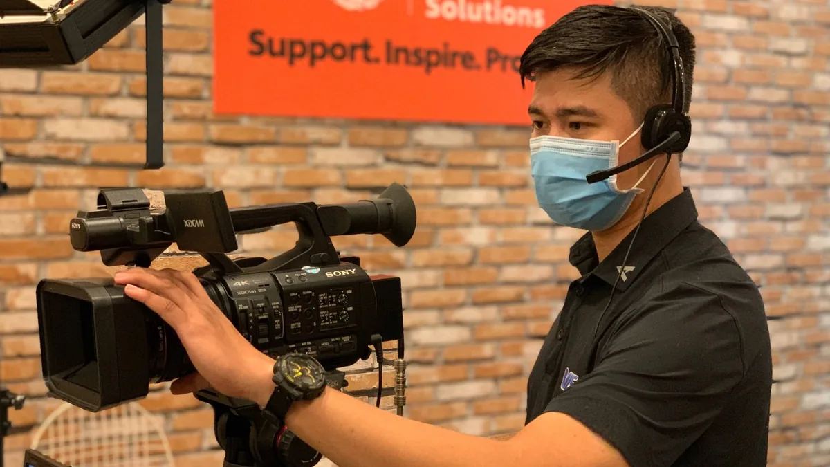Professional videographer with headset operating camera
