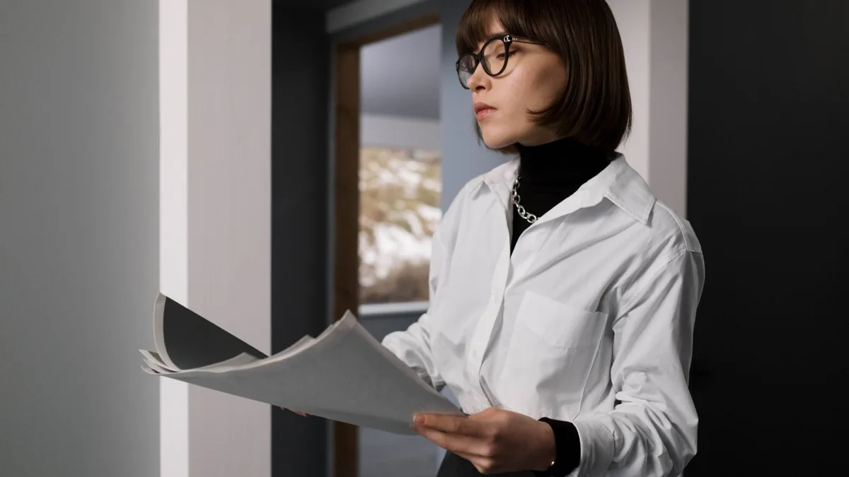 Professional woman in office attire reviewing documents
